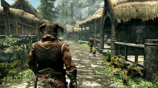 Best open world games: A Skyrim character wearing medieval armor walking through a village.